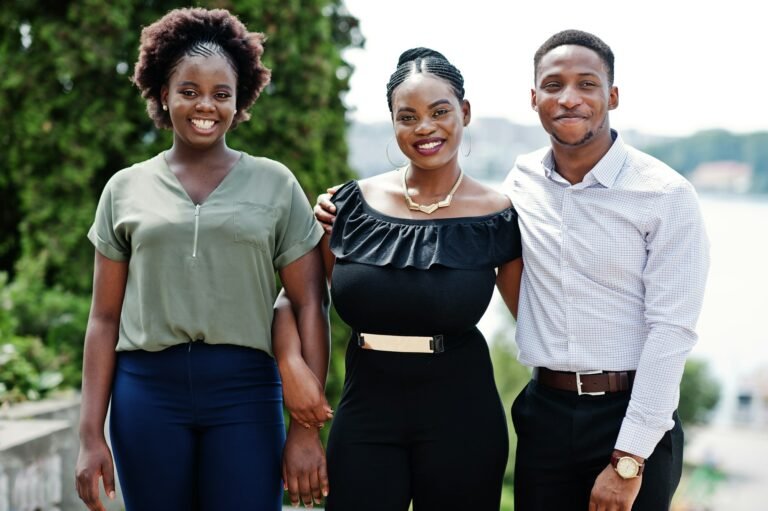 Group of three african american people posed at street of city.